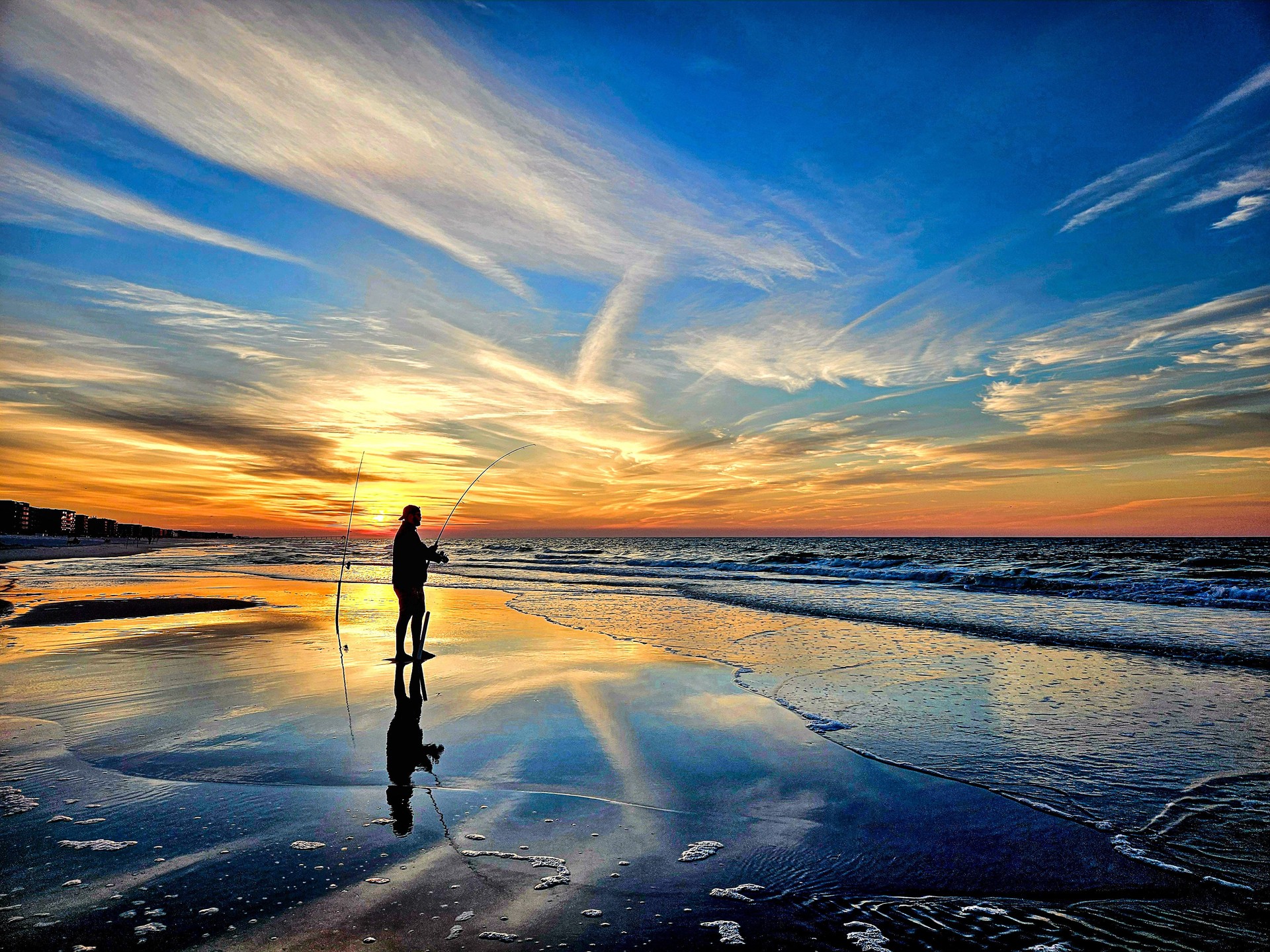 Fisherman Surf Fishing On Coast Of Florida At Sunrise.